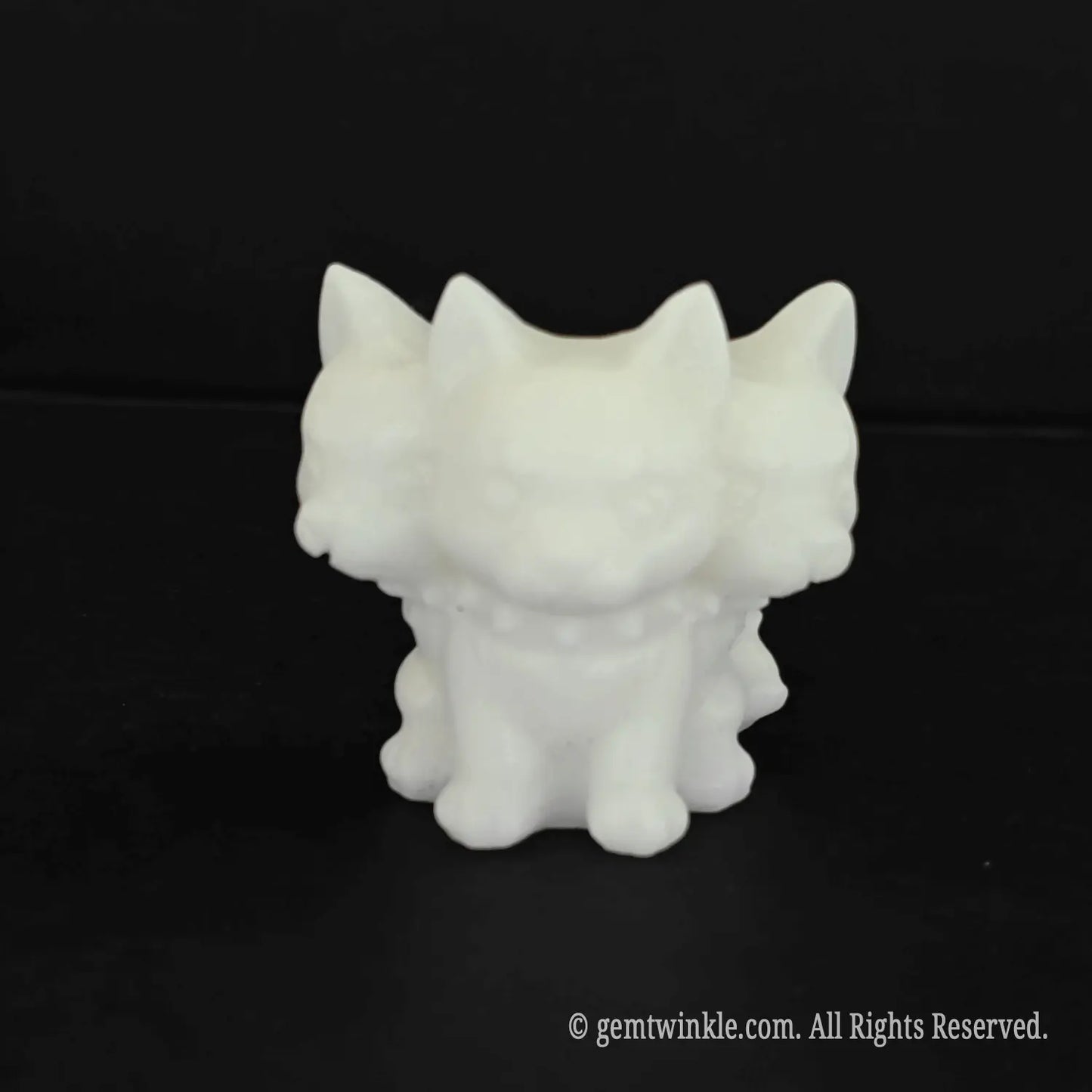 A standalone front view of a 4.5cm cute white marble Cerberus figurine with an oversized three headed puppy design and spiked collar