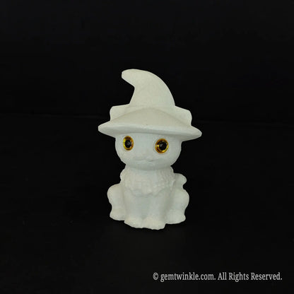 A standalone front view of a white marble witch cat sculpture highlighting the detailed ruffle collar and glossy golden eyes