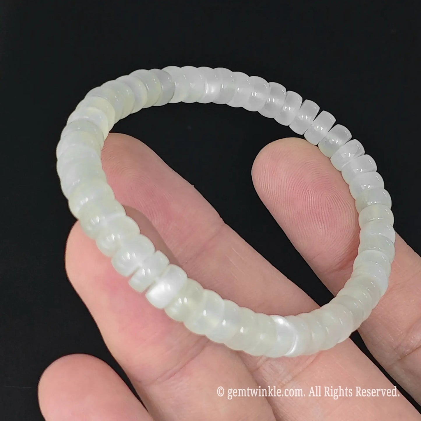 6mm white moonstone saucer slice bead stretch bracelet resting on palm