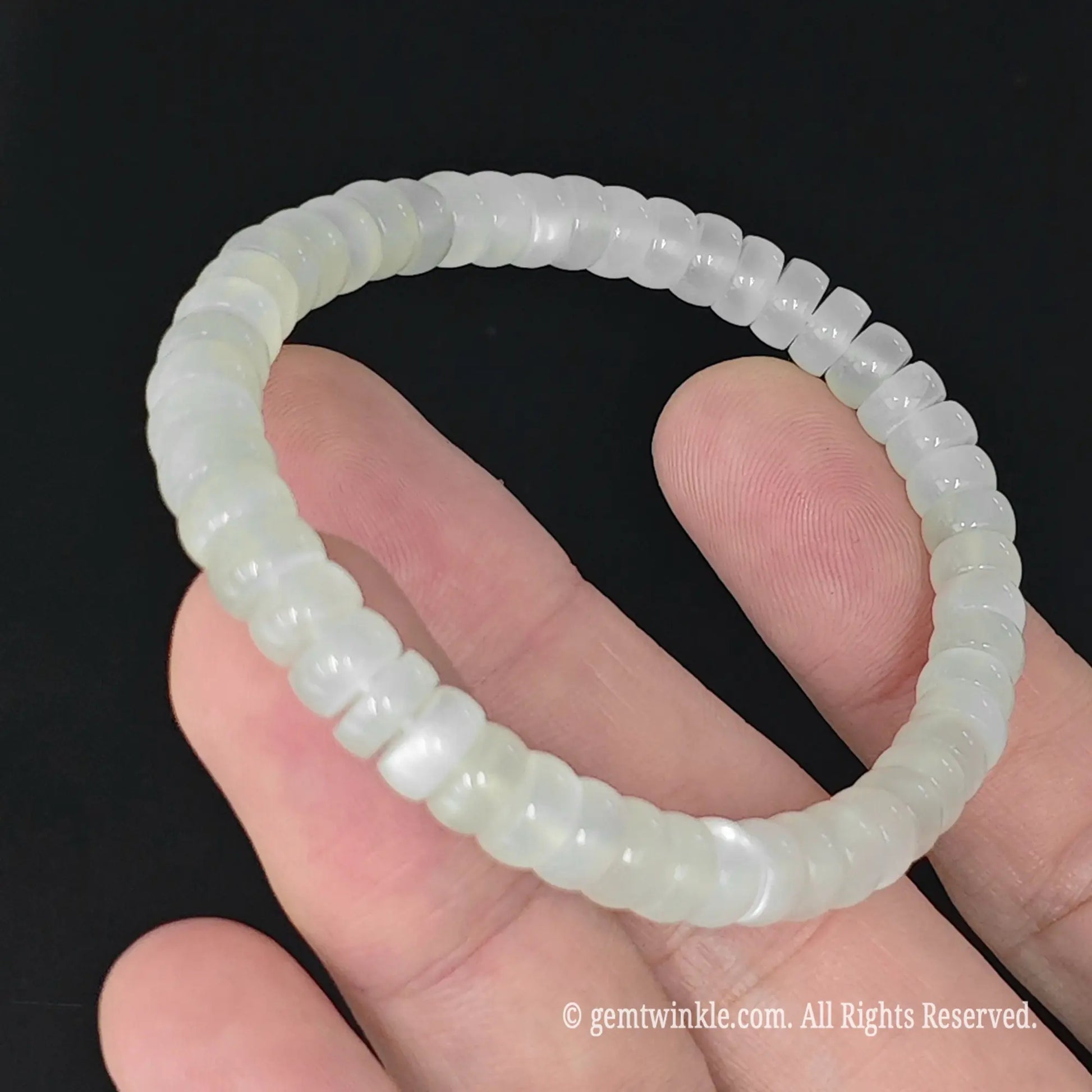 6mm white moonstone saucer slice bead stretch bracelet resting on palm