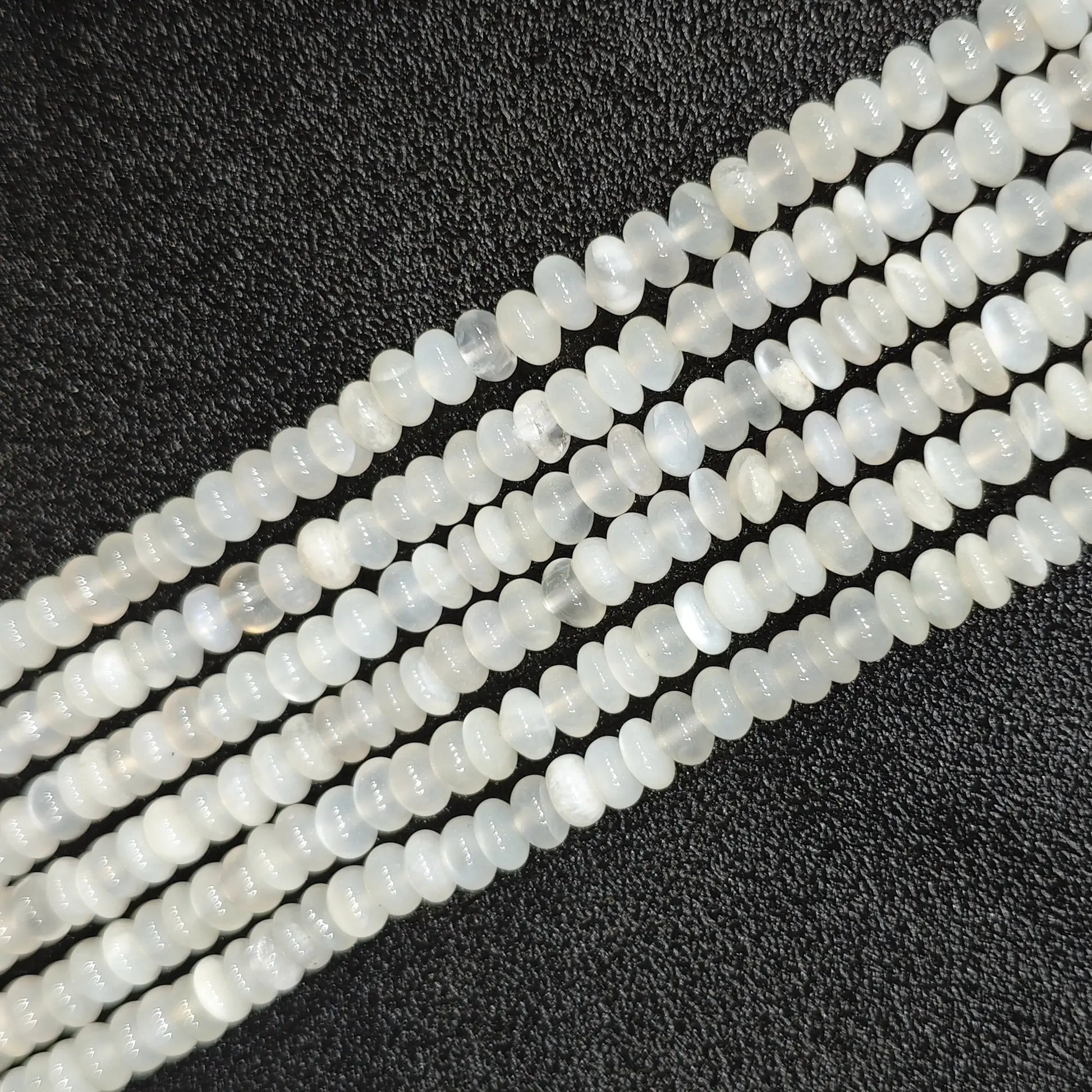 Macro closeup of natural white moonstone smooth rondelle beads 6x4mm showing translucent milky sheen