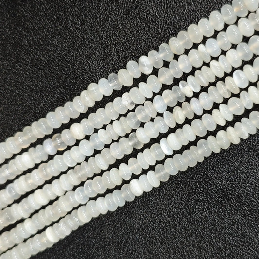 Macro closeup of natural white moonstone smooth rondelle beads 6x4mm showing translucent milky sheen