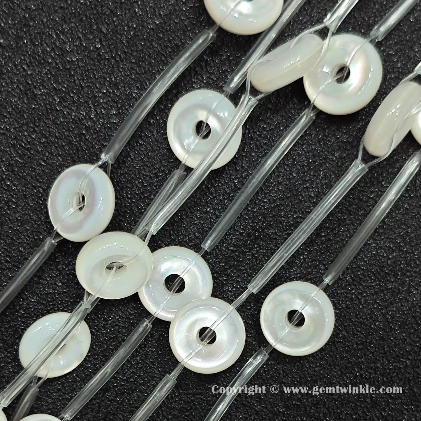Perspective view of white mother of pearl ring beads showing uniform 12mm outer diameter