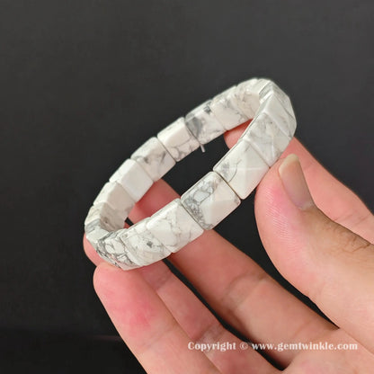 Angle view of white turquoise style stackable bangle held showcasing fine polished rectangle beads