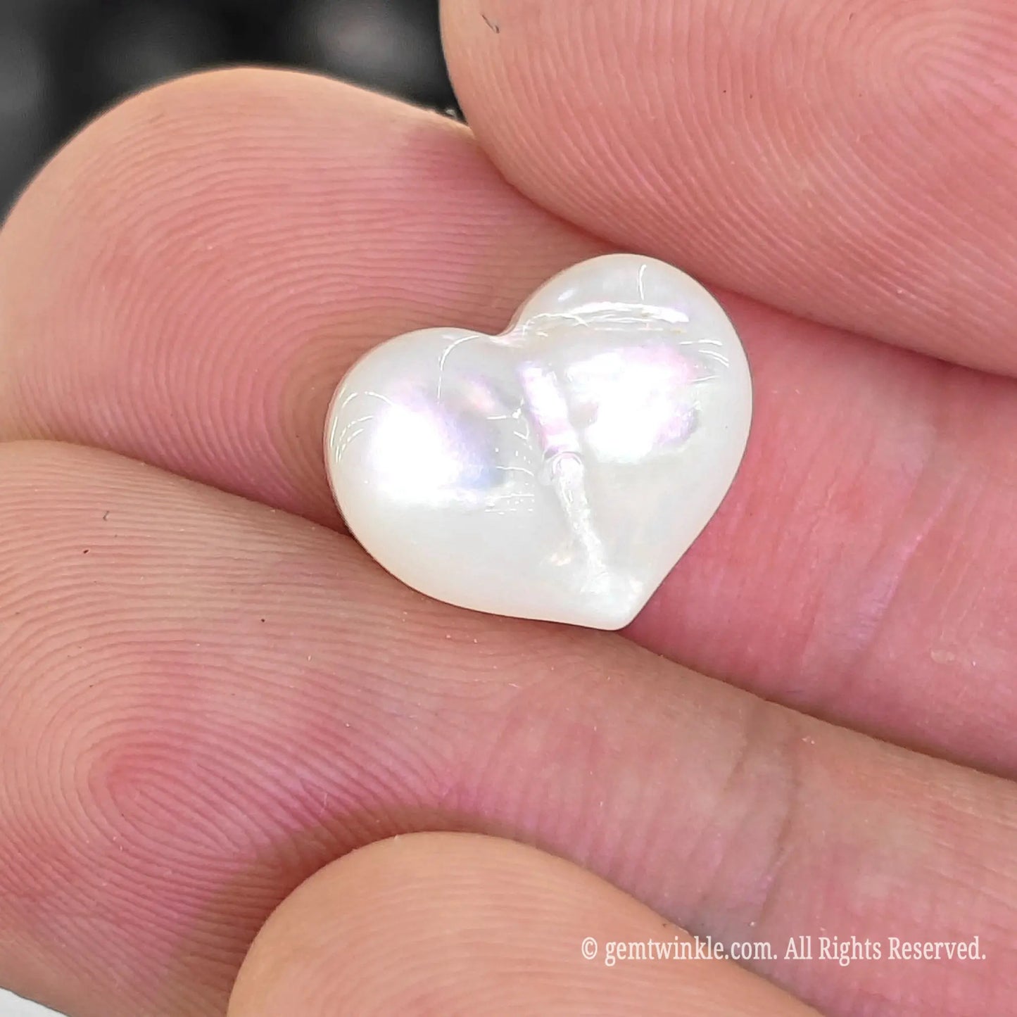 White MOP puffy heart bead top angle view showing vertical top to bottom straight drill hole
