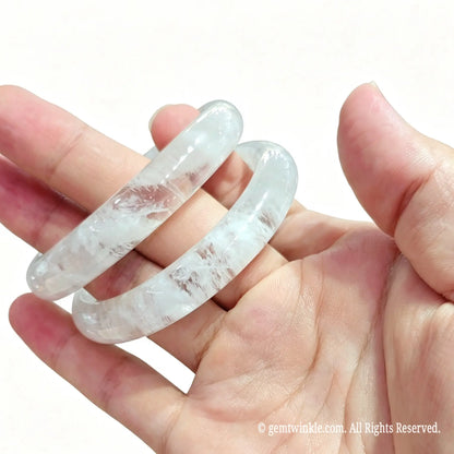 Pair of white garden quartz wristbands held in hand for live stream sales and single piece selection