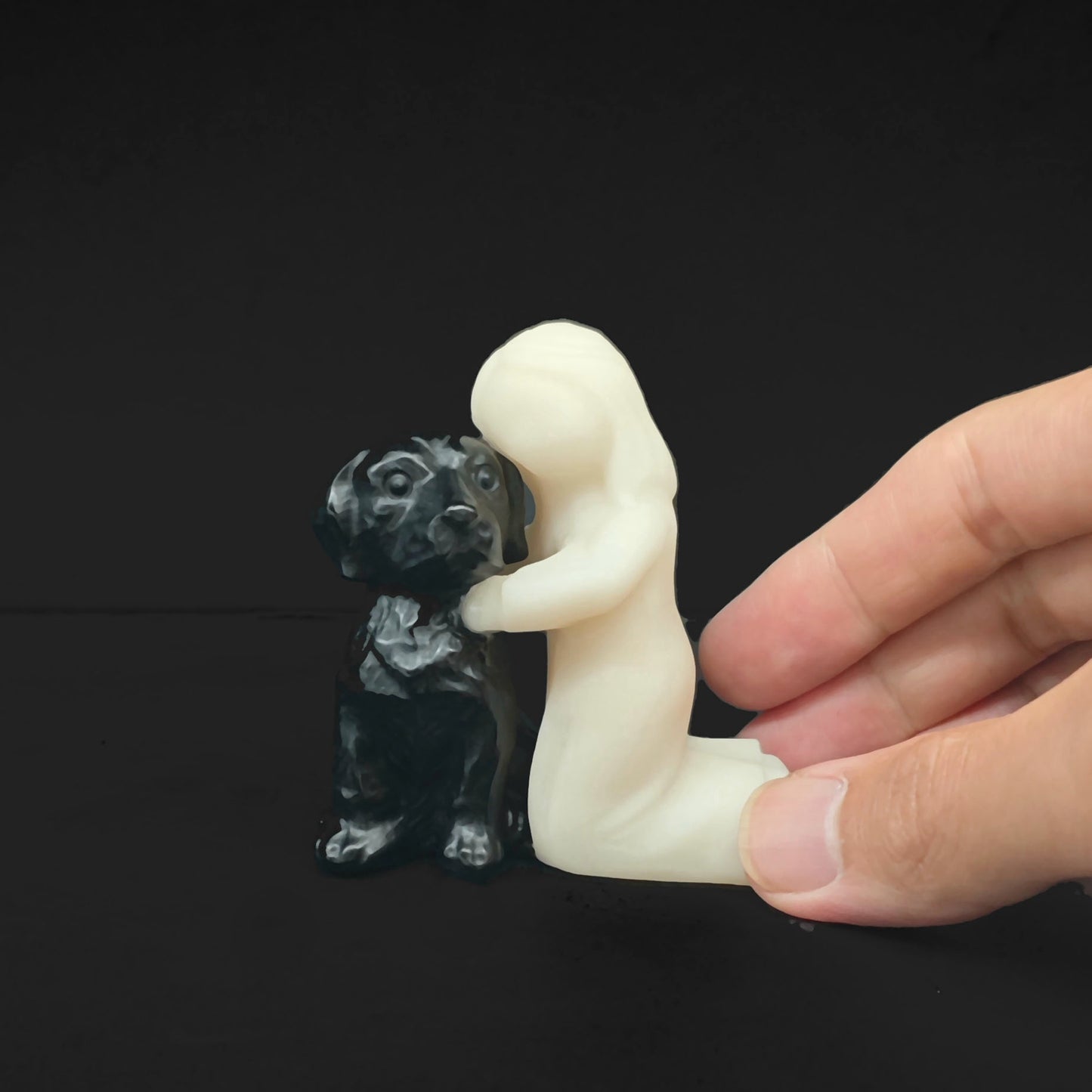 Hand view of a white marble girl holding a black obsidian dog statue showing the smooth texture and ideal size for retail gift displays