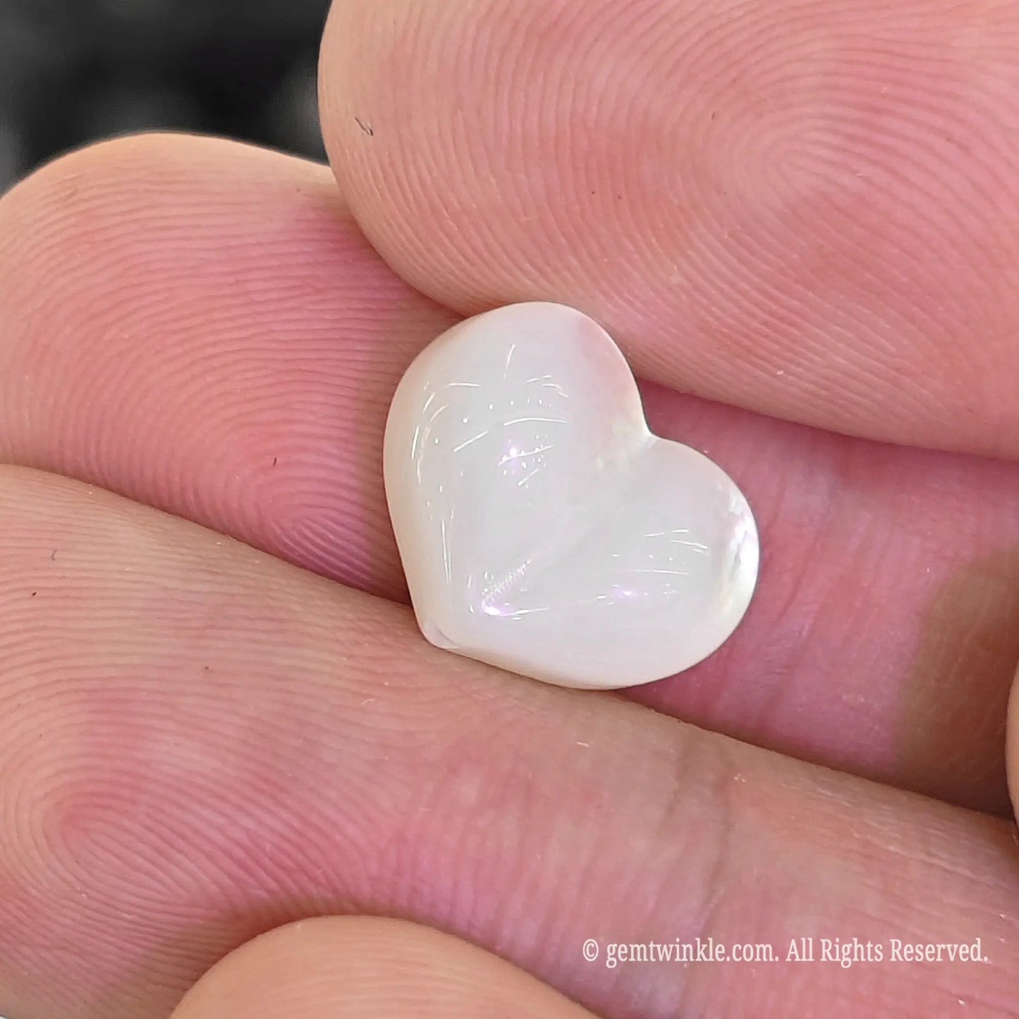 White mother of pearl 12mm heart bead close up view showing defined center crease and milky luster