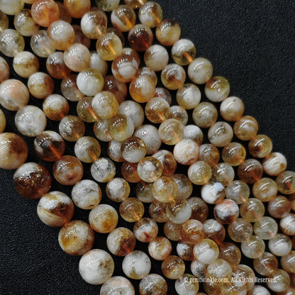 Diagonal close up shot of wholesale crackle textured citrine phantom round beads for gothic style jewelry making