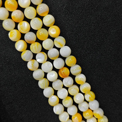Boutique wholesale natural spiral shell loose beads showing round enhanced strands with bright yellow and cream growth bands