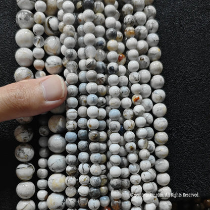 hand holding a massive bundle of natural blue opal matrix crystal strands showing volume inventory readiness for boutique sourcing