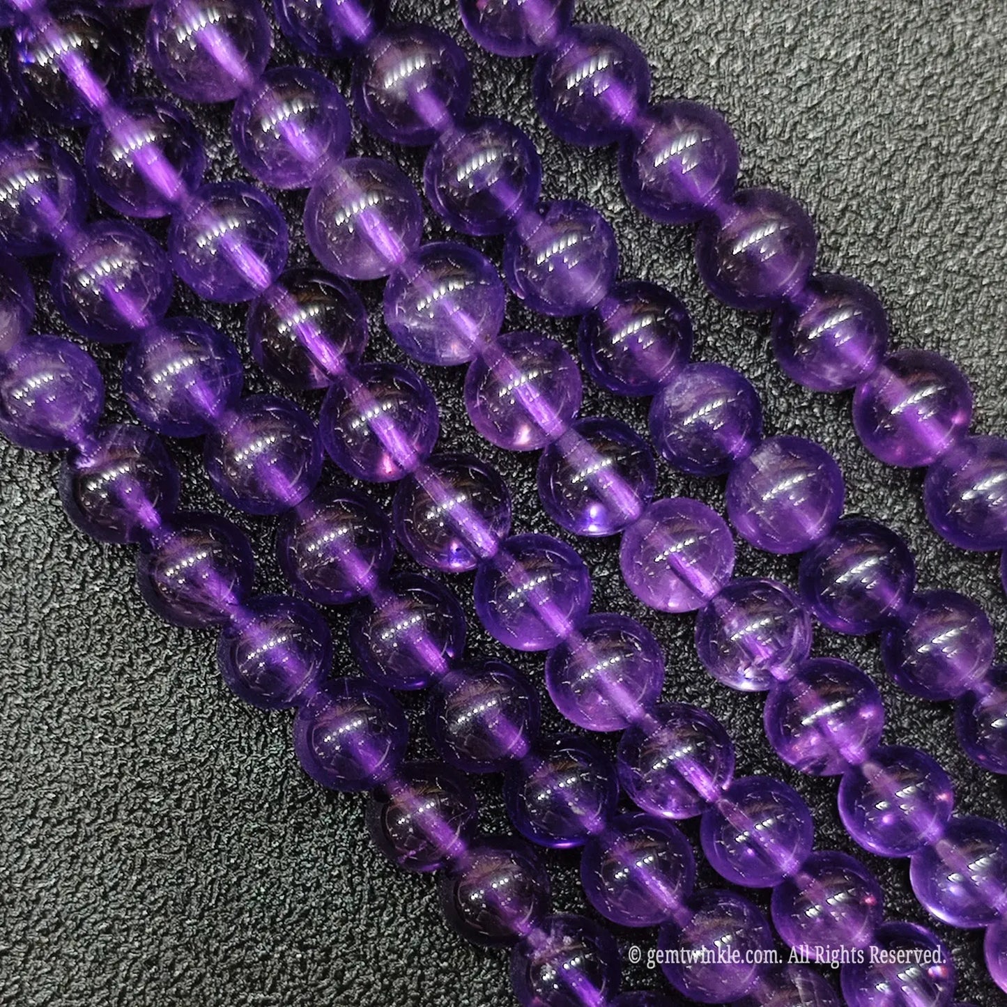 High angle view of wholesale translucent royal violet amethyst crystal beads strands for luxury boutique shops