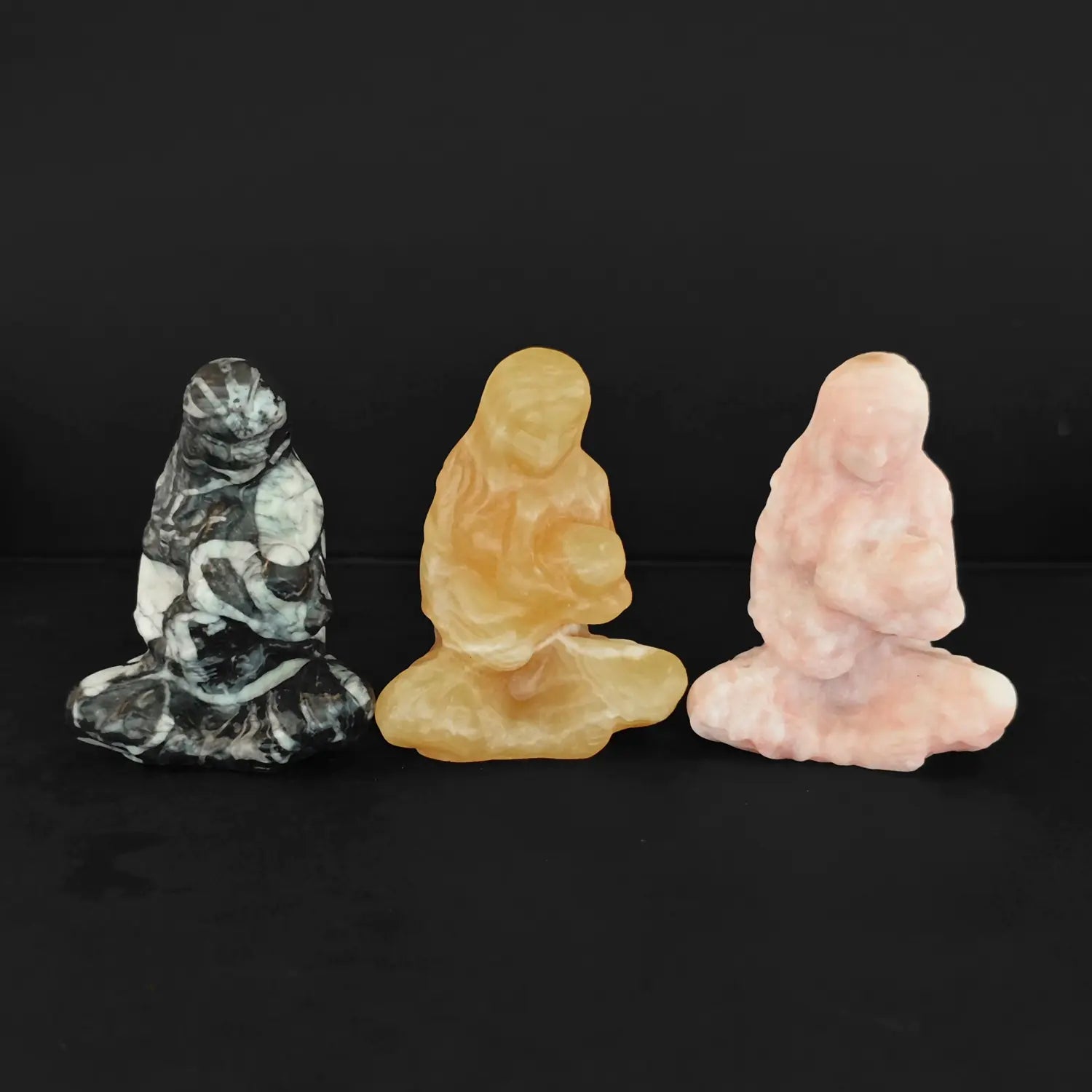three mini gemstone mother holding baby figurines representing the virgin mary and child jesus
