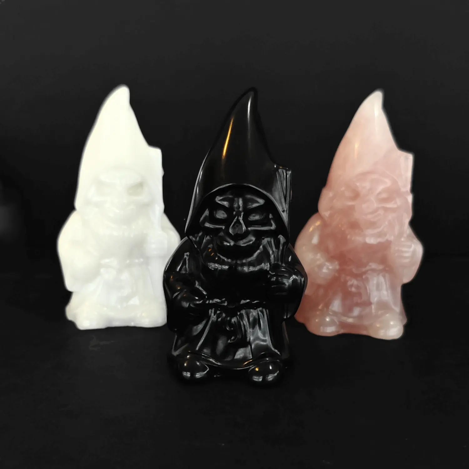three eight centimeter crystal gnome statues made of white marble obsidian and rose quartz