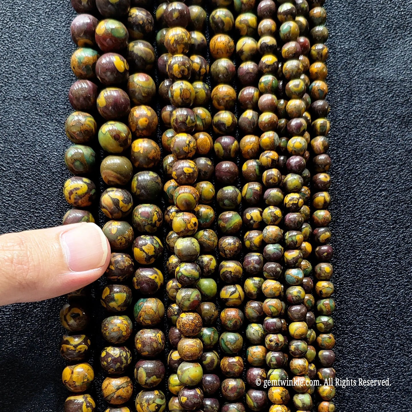 hand holding a massive bundle of multi color nuwa jasper crystal strands showing volume inventory readiness for boutique sourcing