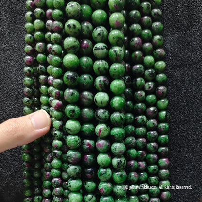 hand holding a massive bundle of green and red ruby zoisite crystal strands showing volume inventory readiness