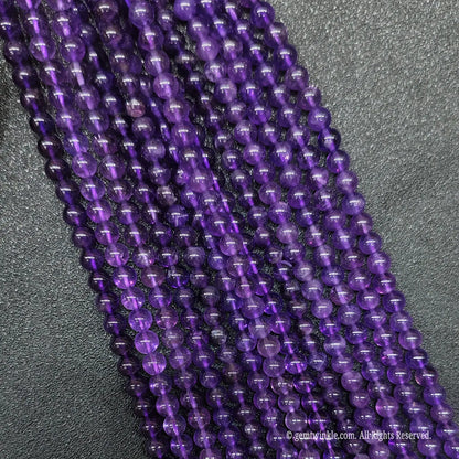 Multiple parallel rows of wholesale translucent violet amethyst round crystal beads for artisan jewelry making