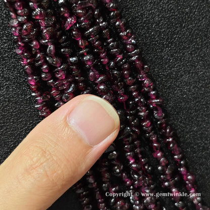 Natural wine red garnet chip bead strand held over hand for size scale