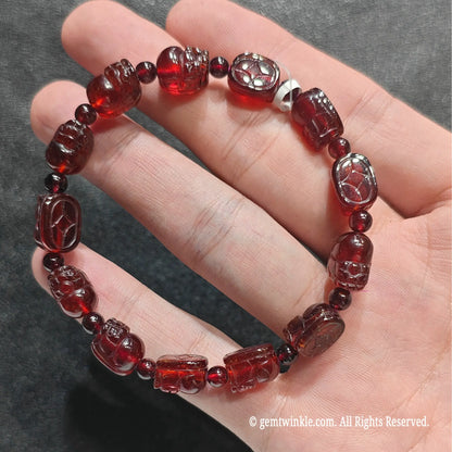Close up view of wine red garnet pixiu bead wristband displaying high vitreous polish and clear crimson clarity