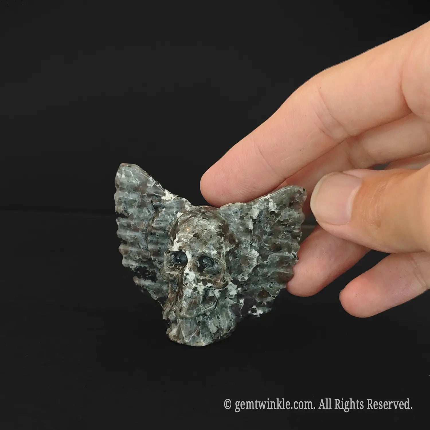 Handheld serpentine stone winged skull carving