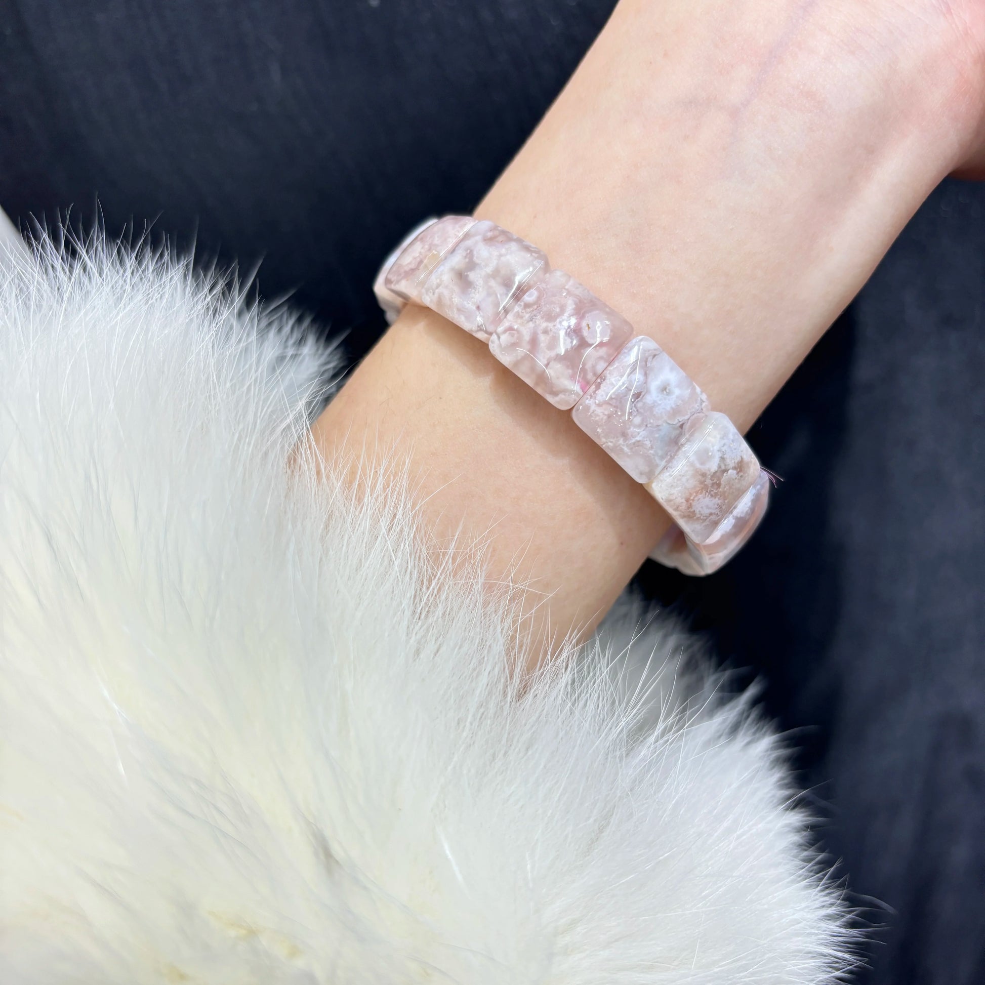 Woman wearing a lovely natural flower agate elastic stretch bracelet on wrist.