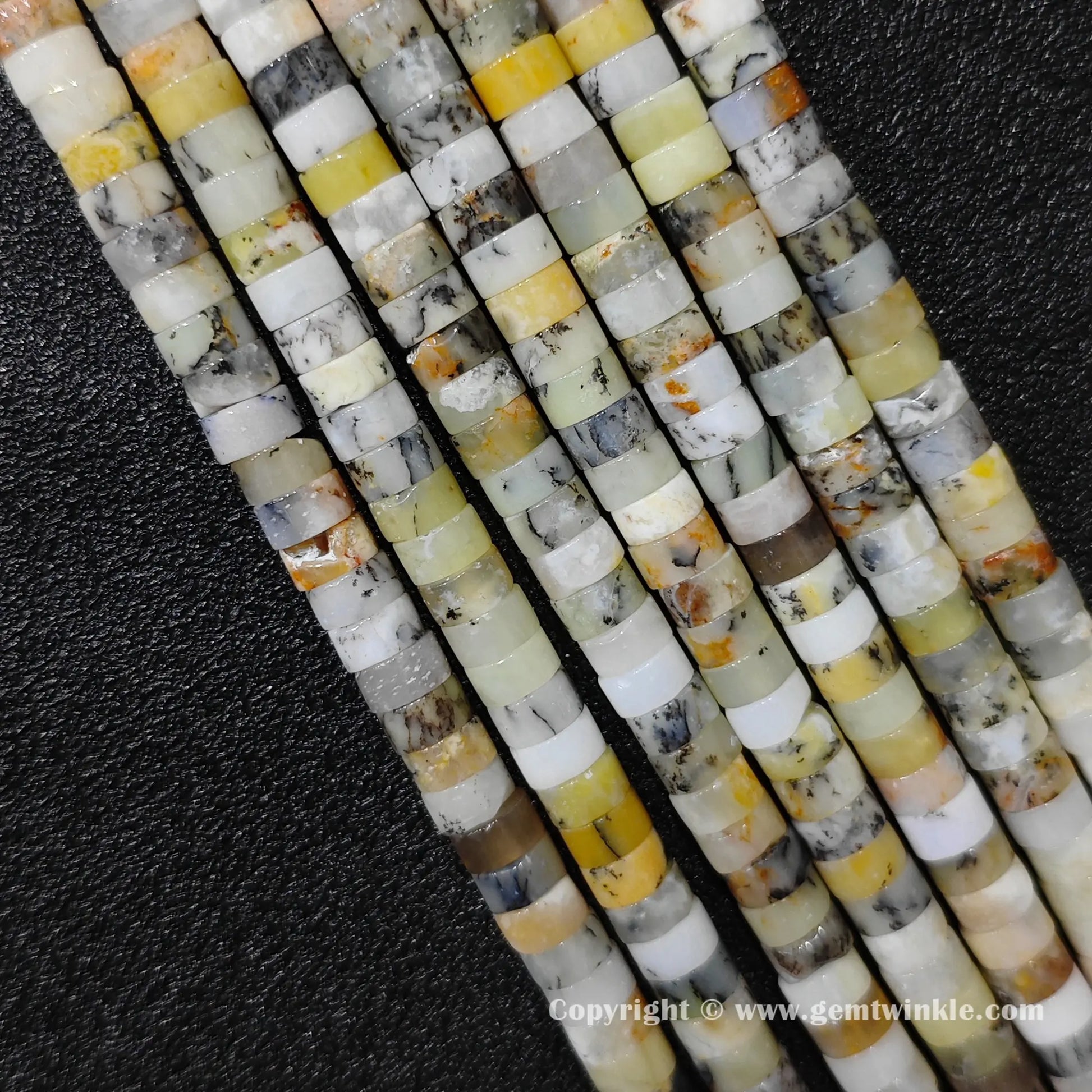 Perspective view of yellow australian opal heishi spacer beads showing uniform disc thickness