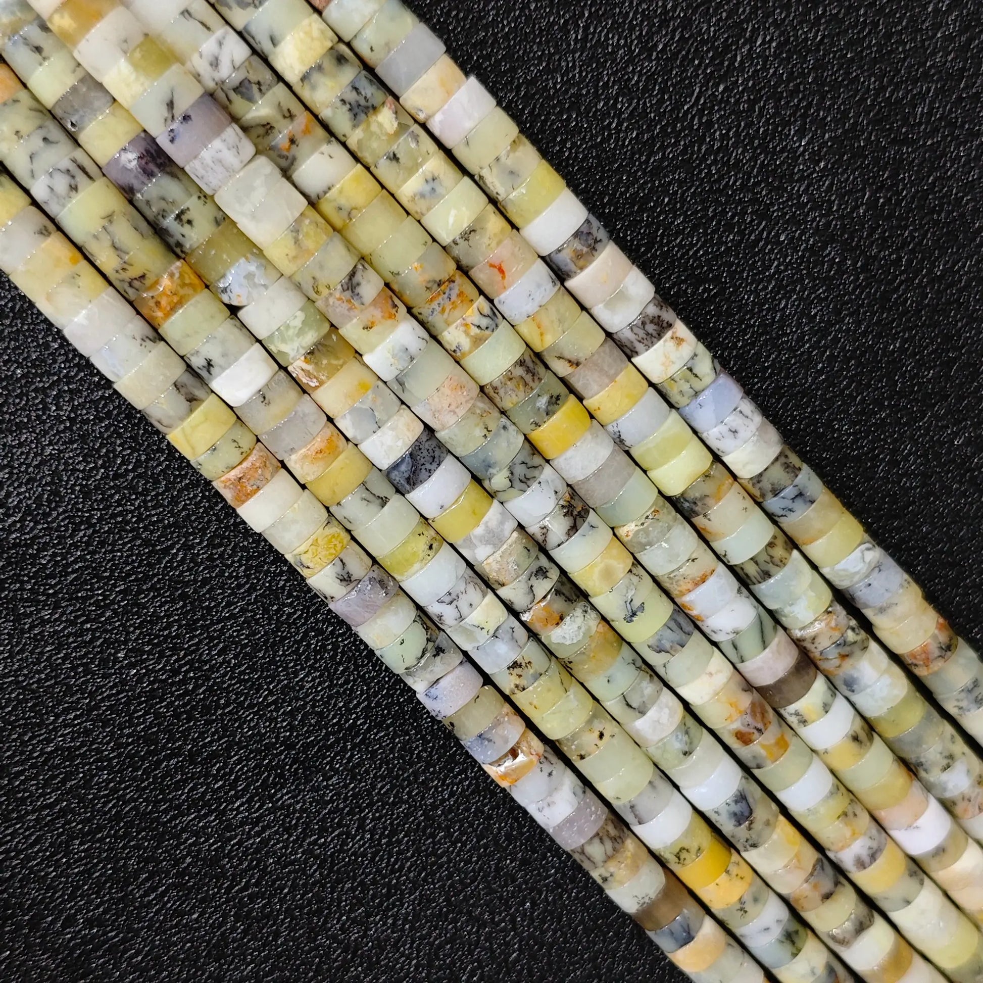 Macro closeup of natural yellow australian opal heishi rondelle beads 6x3mm showing honey tones