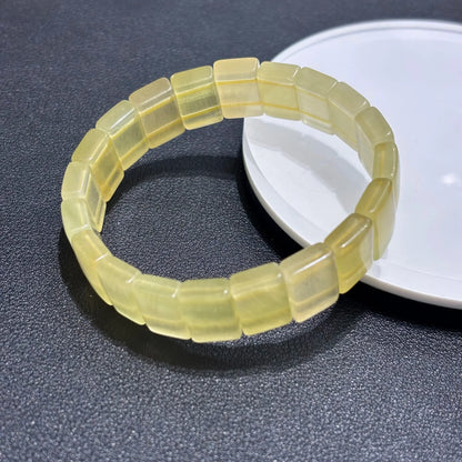 Natural Yellow Fluorite Bangle Bracelet displayed on a white plate, emphasizing the square bead shape and smooth finish.