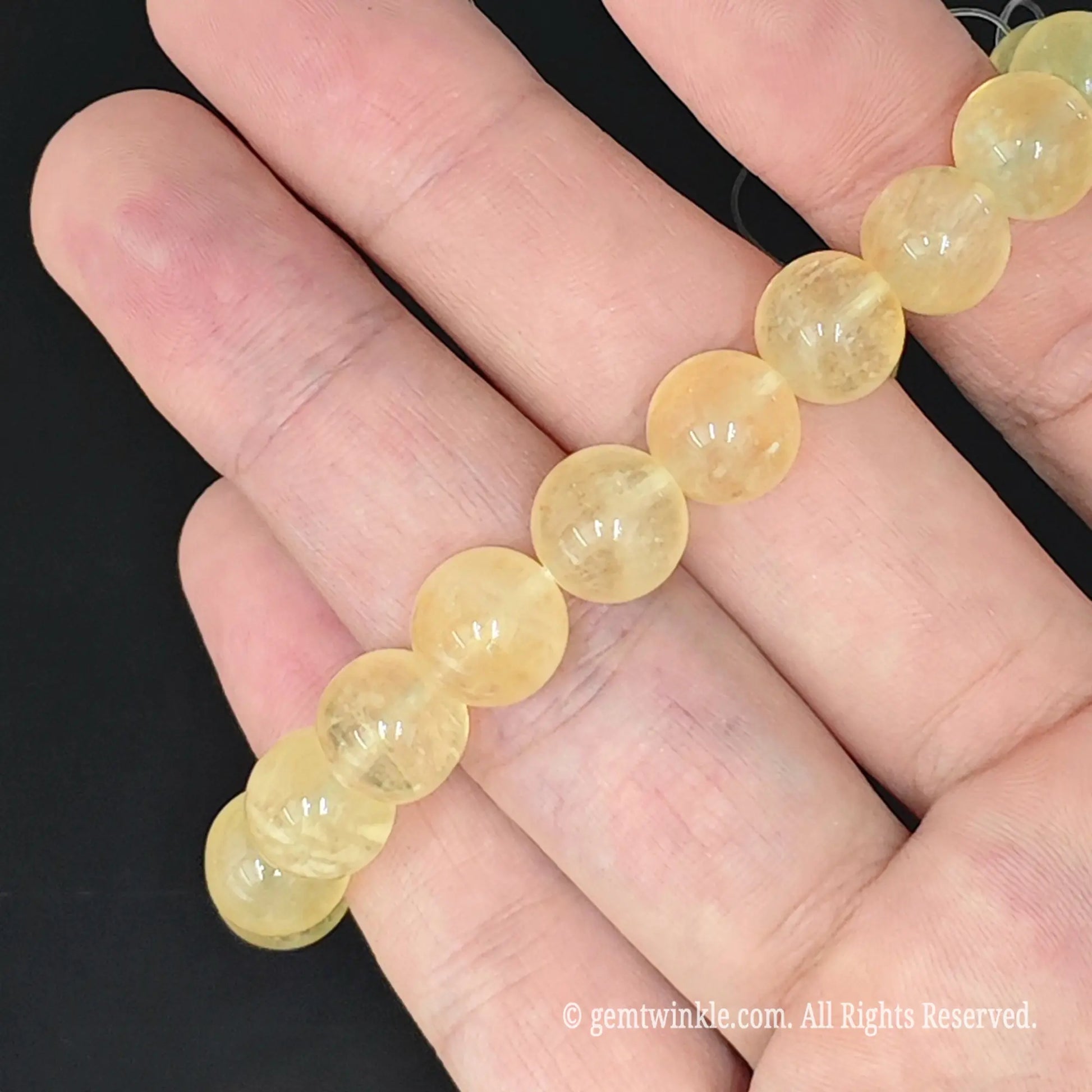 side view of natural yellow fluorite round bead stretch bracelet worn on wrist