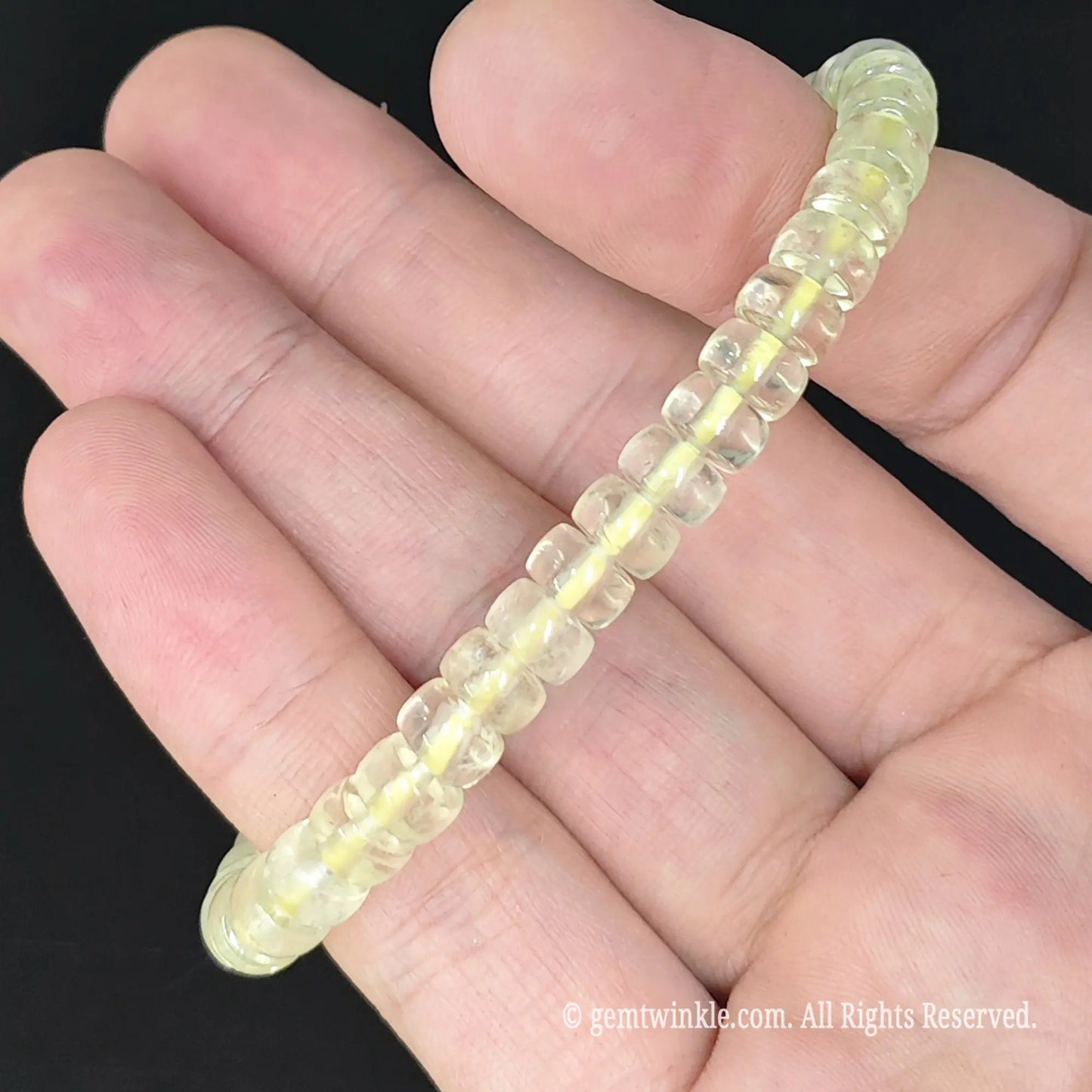top view of yellow lemon quartz disc bead stretch bangle on palm