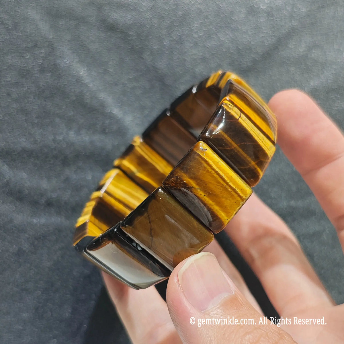Close up view of yellow tiger eye plate beads showing smooth polish and rich brown and gold optical banding[cite: 5]