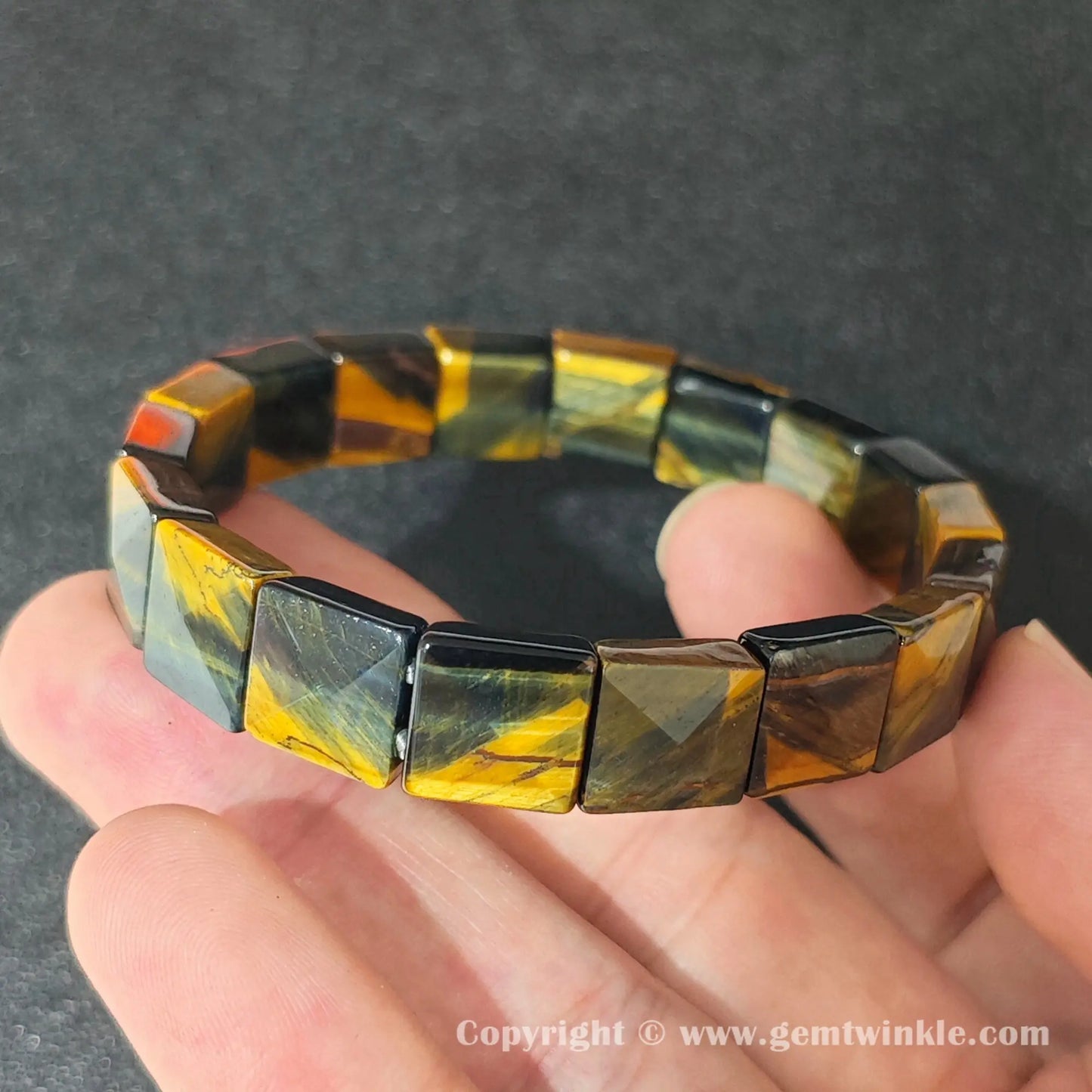natural yellow blue tigers eye square plate bracelet displayed over palm highlighting glossy polish