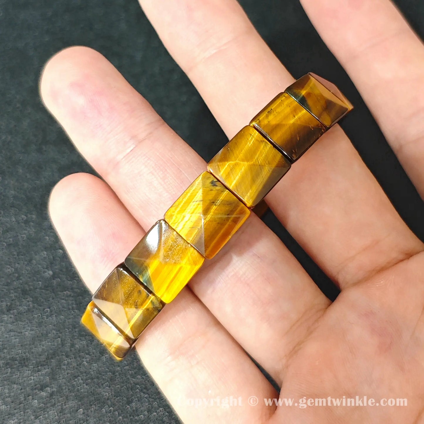 close up of golden yellow tigers eye 11x11mm pyramid faceted beads on elastic cord