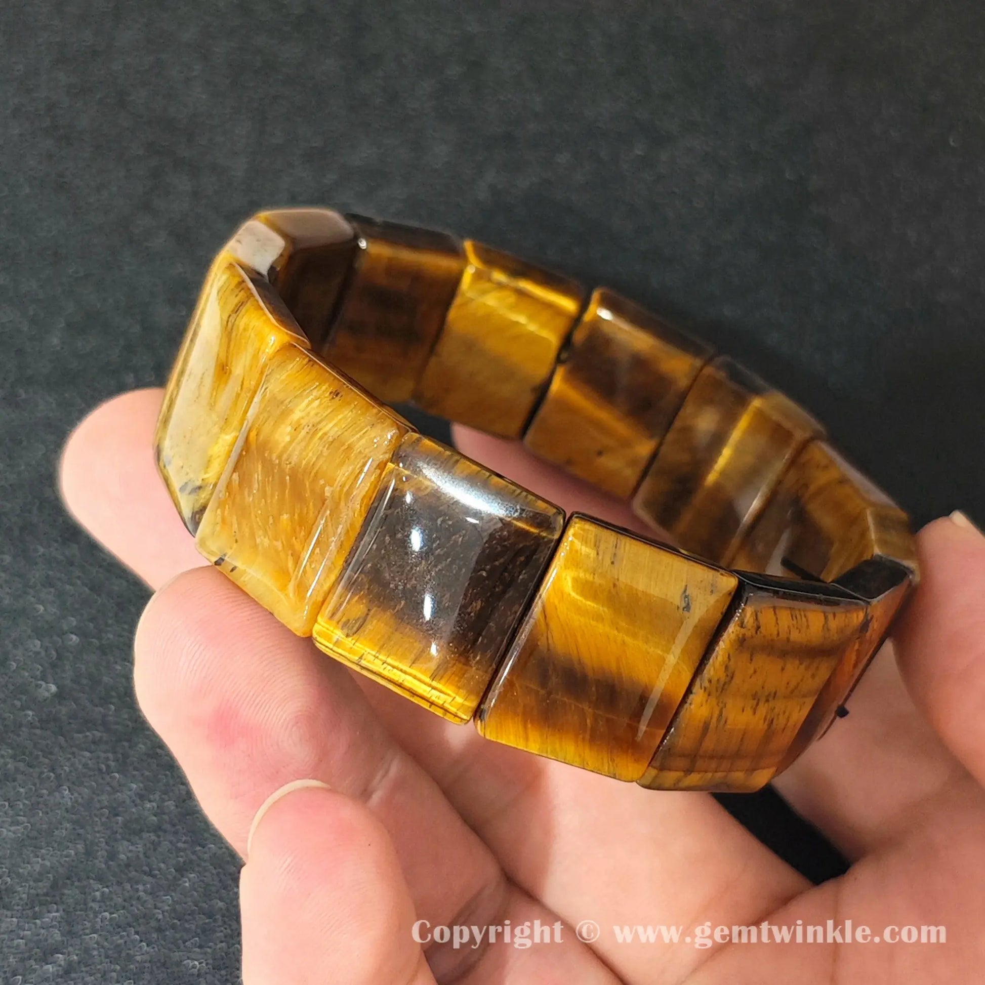 side view of natural yellow tigers eye stretch bracelet showcasing machine polished flat plates