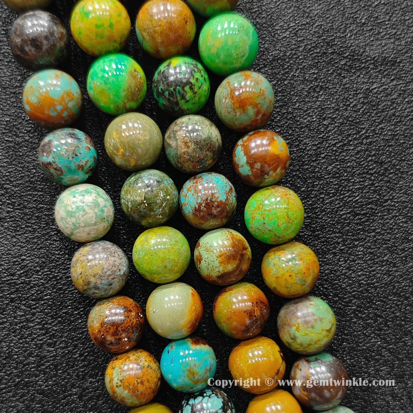 Perspective view of yellowish green chrysocolla round beads showing polished finish across multiple sizes