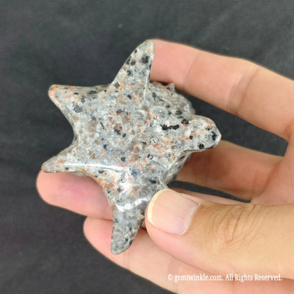 Bottom view of yooperlite tree stump carving showing star shaped root base and natural mineral speckled texture
