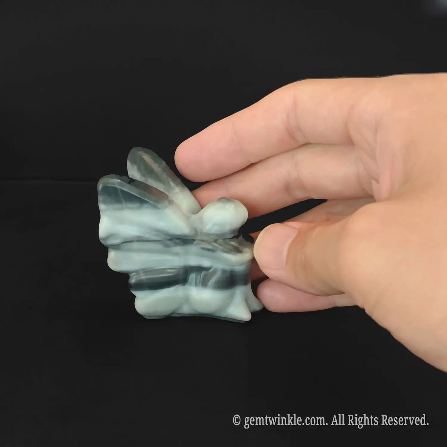 Back details of carved zebra stripe stone flower fairy showing swirling black and white patterns