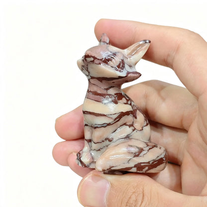 Zebra jasper fox figurine held in hand showing brown and cream striped head with perked ears